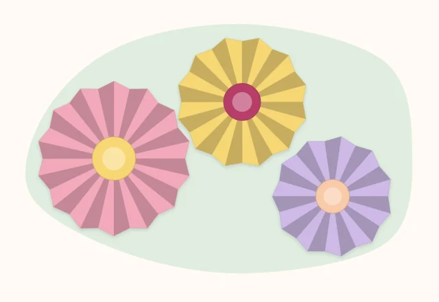 Three round accordion-fold paper flowers with contrasting centers