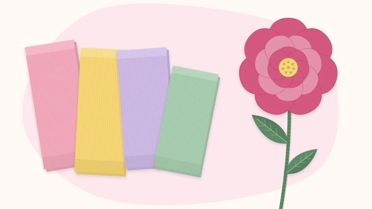 Folds of crepe paper in several colors beside one finished crepe paper flower