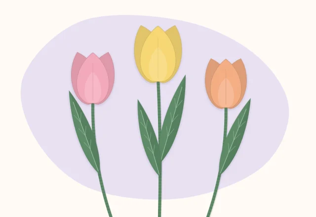 Three crepe paper tulips in different colors with long green leaves