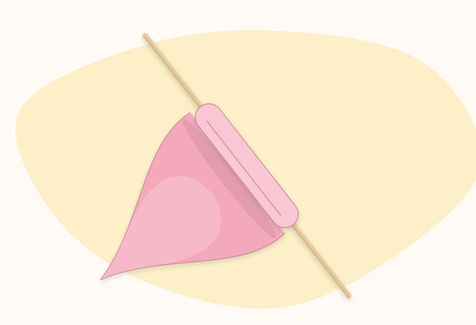 The edge of a paper petal being curled around a wooden skewer
