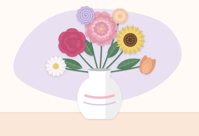 A paper flower arrangement in a simple vase with flowers at varied heights