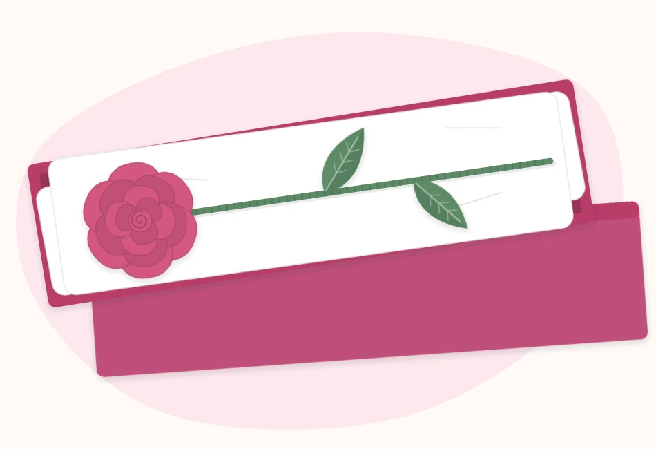 A single long-stem paper rose lying in a narrow open gift box lined with tissue