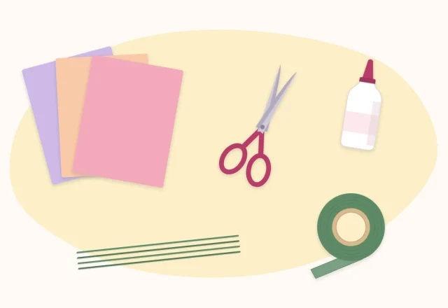 Flat lay of scissors, a glue bottle, floral wire, a roll of floral tape and colored paper sheets