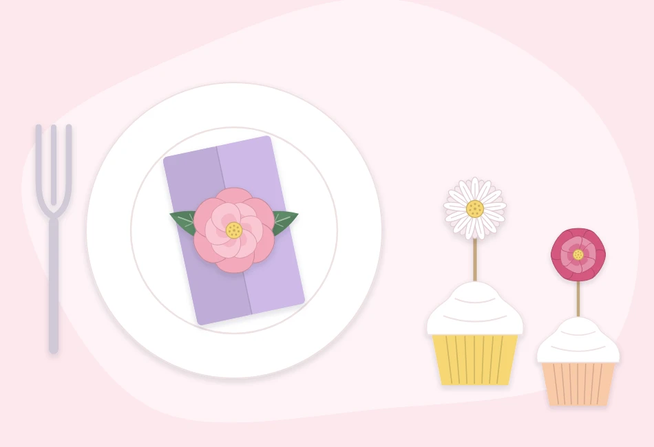 Place setting with a small paper flower resting on a folded napkin beside cupcakes decorated with paper flower toppers
