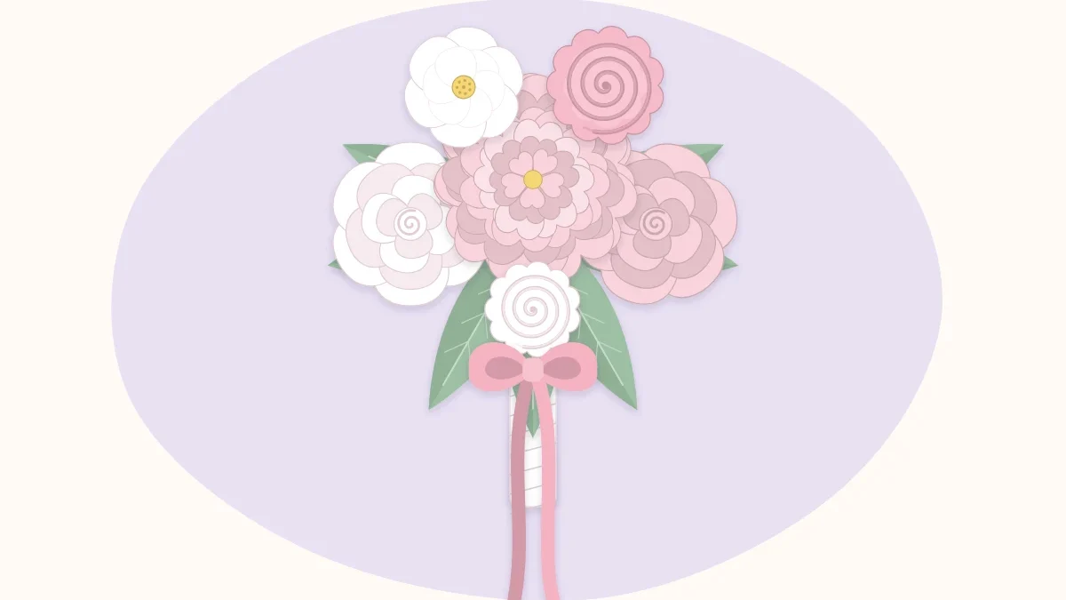 A white and blush paper flower bridal bouquet with long ribbon tails