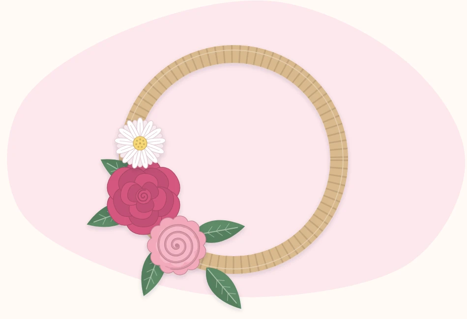 Bare wreath ring with a first cluster of three paper flowers and green leaves attached on one side