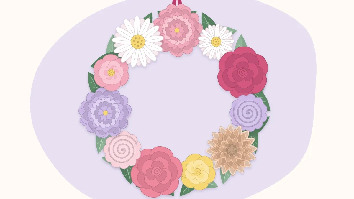Round wreath covered with paper flowers in pinks and peach with green paper leaves