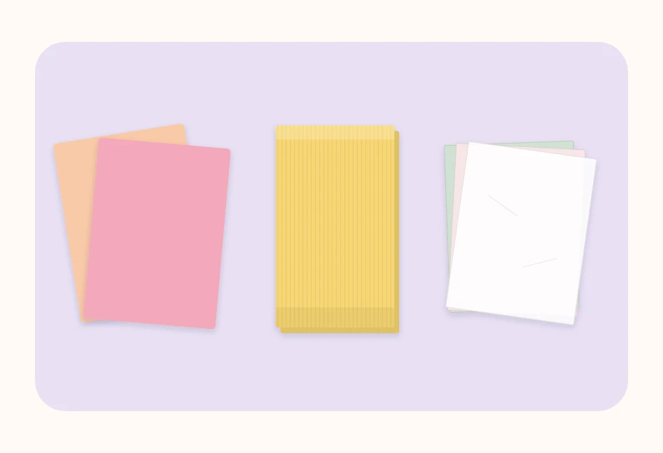 A sheet of cardstock, a fold of crepe paper and a stack of tissue paper side by side