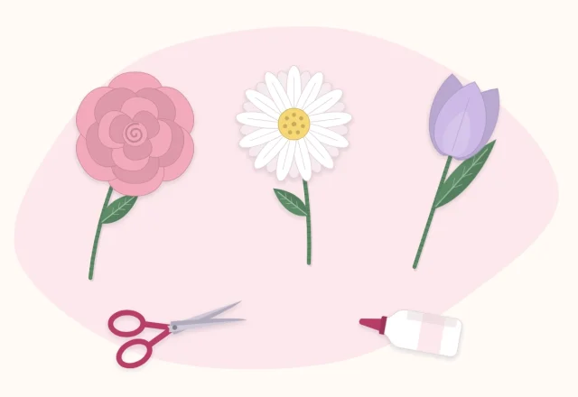 A simple paper rose, daisy and tulip lying beside scissors and a glue bottle