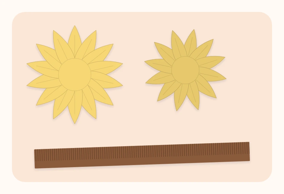 Two rings of yellow pointed paper petals and a long brown fringed strip laid flat