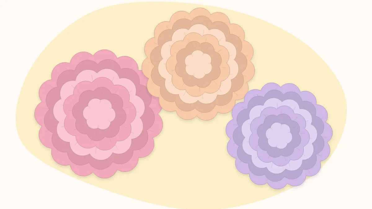 Three fluffy tissue paper pom flowers in pink, peach and lilac